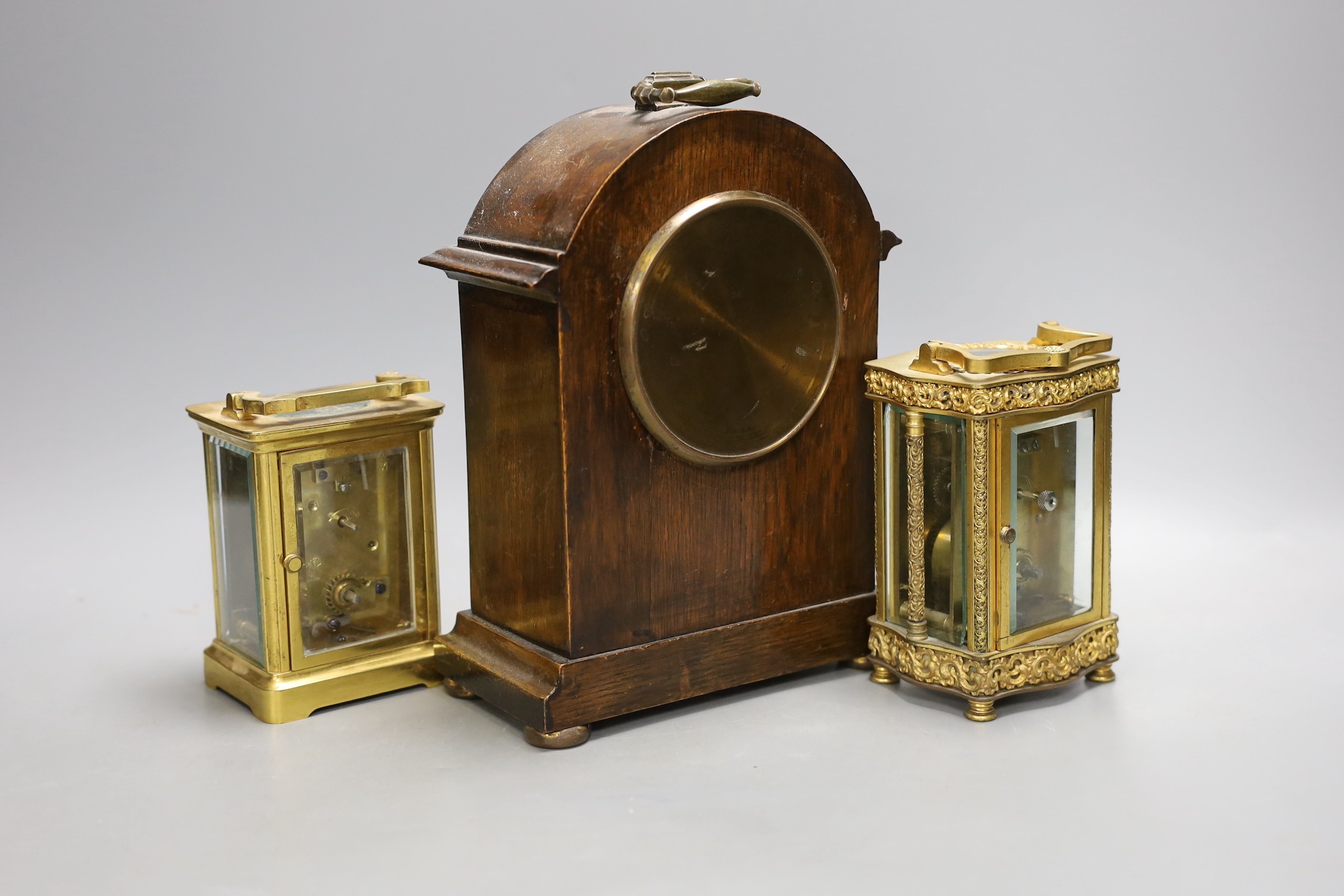 Two French brass carriage timepieces and an oak mantel clock, tallest carriage clock 12 cms high.